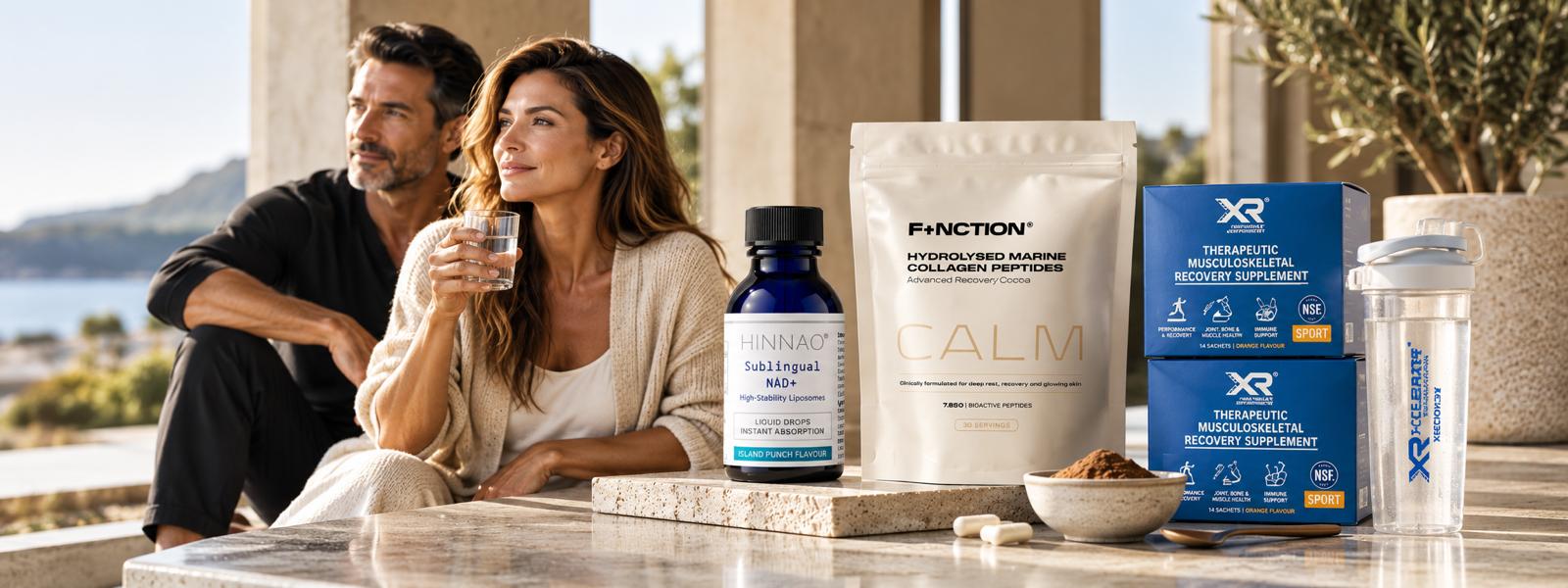 A couple relaxing on a sunny terrace beside HINNAO Sublingual NAD+, F+NCTION CALM collagen and XR recovery supplements